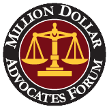 Logo for the Million Dollar Advocates Forum featuring a gold scales-of-justice emblem inside a burgundy circle with white text, on a green background.
